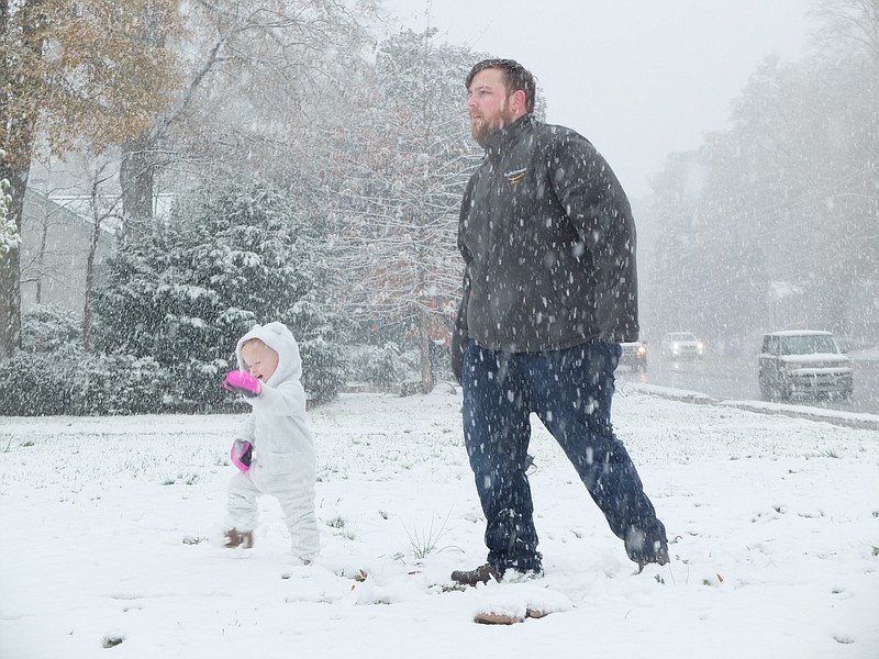 Little Elliott Runion, 19 months, enjoys his first look at snow with his father Joshua at 601 Walnut Avenue in Dalton.
