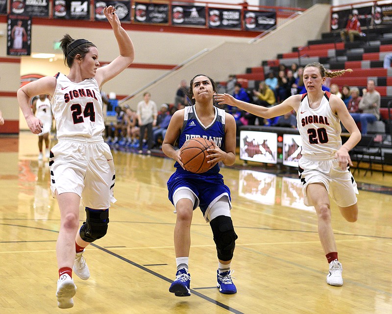 Red Bank's Layla Babb (3) drives to the basket between Signal Mountain's Mary Witherspoon (24) and Maia Racker (20).  The Red Bank Lady Lions visited the Signal Mountain Lady Eagles in TSSAA basketball action on December 8, 2017.