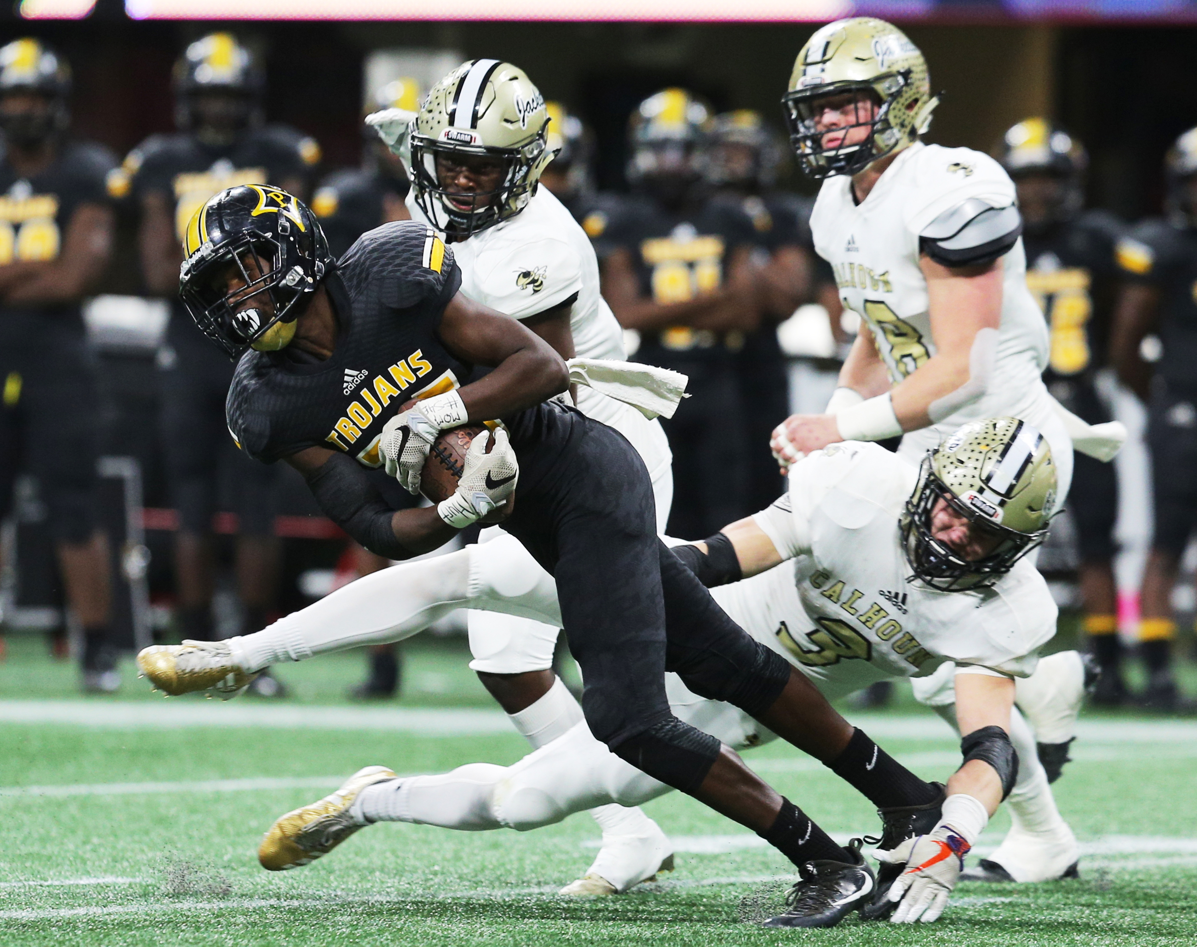Peach County's Mallard Thomas (26) is tripped up by Calhoun's Brannon Spector (3) during the Class AAA State Championship football game between Calhoun and Peach County Friday, Dec. 8, 2017 at the Mercedes-Benz Stadium in Atlanta, Ga.