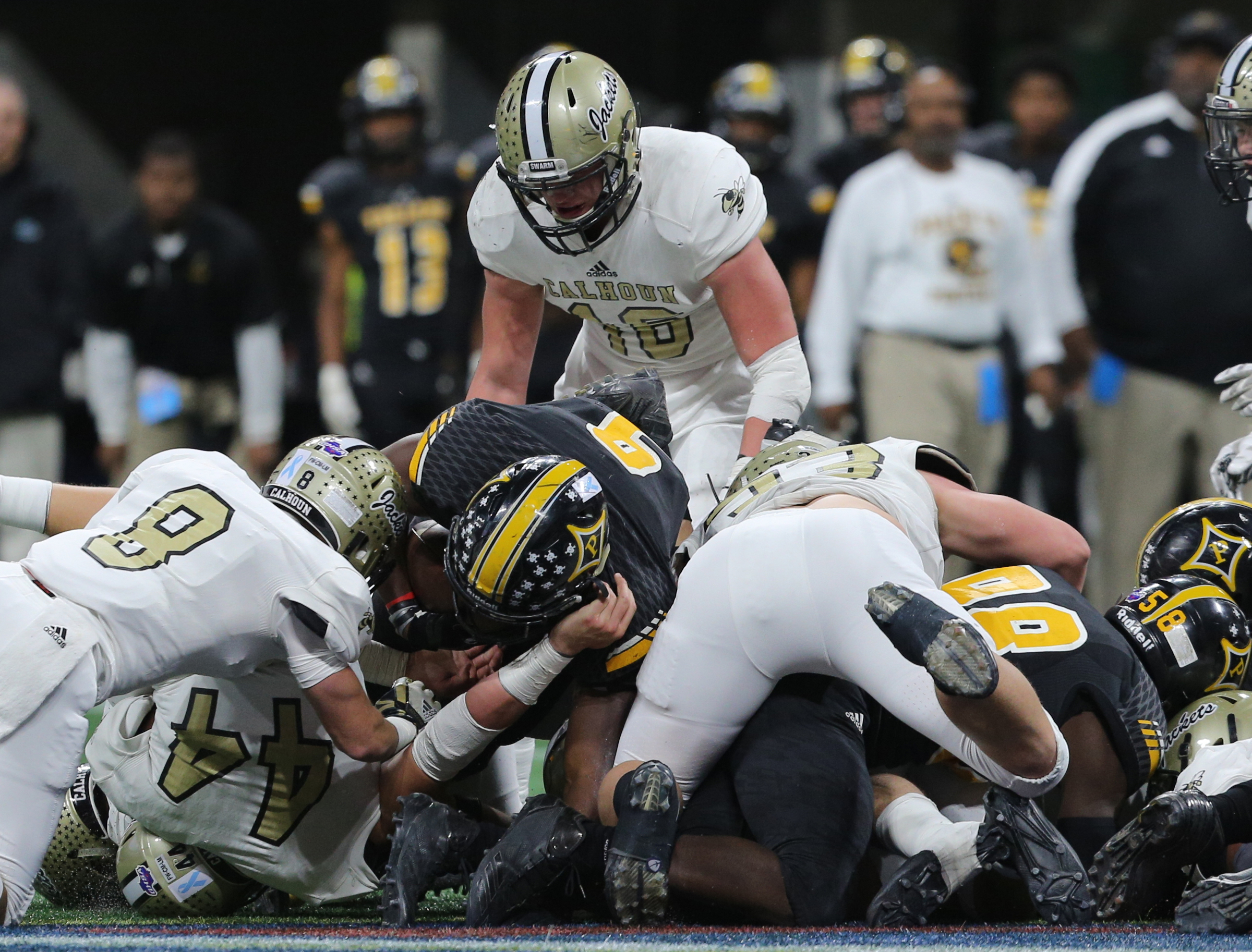Calhoun players pile up on top of Peach County players to stop a drive during the Class AAA State Championship football game Friday, Dec. 8, 2017 at the Mercedes-Benz Stadium in Atlanta, Ga.