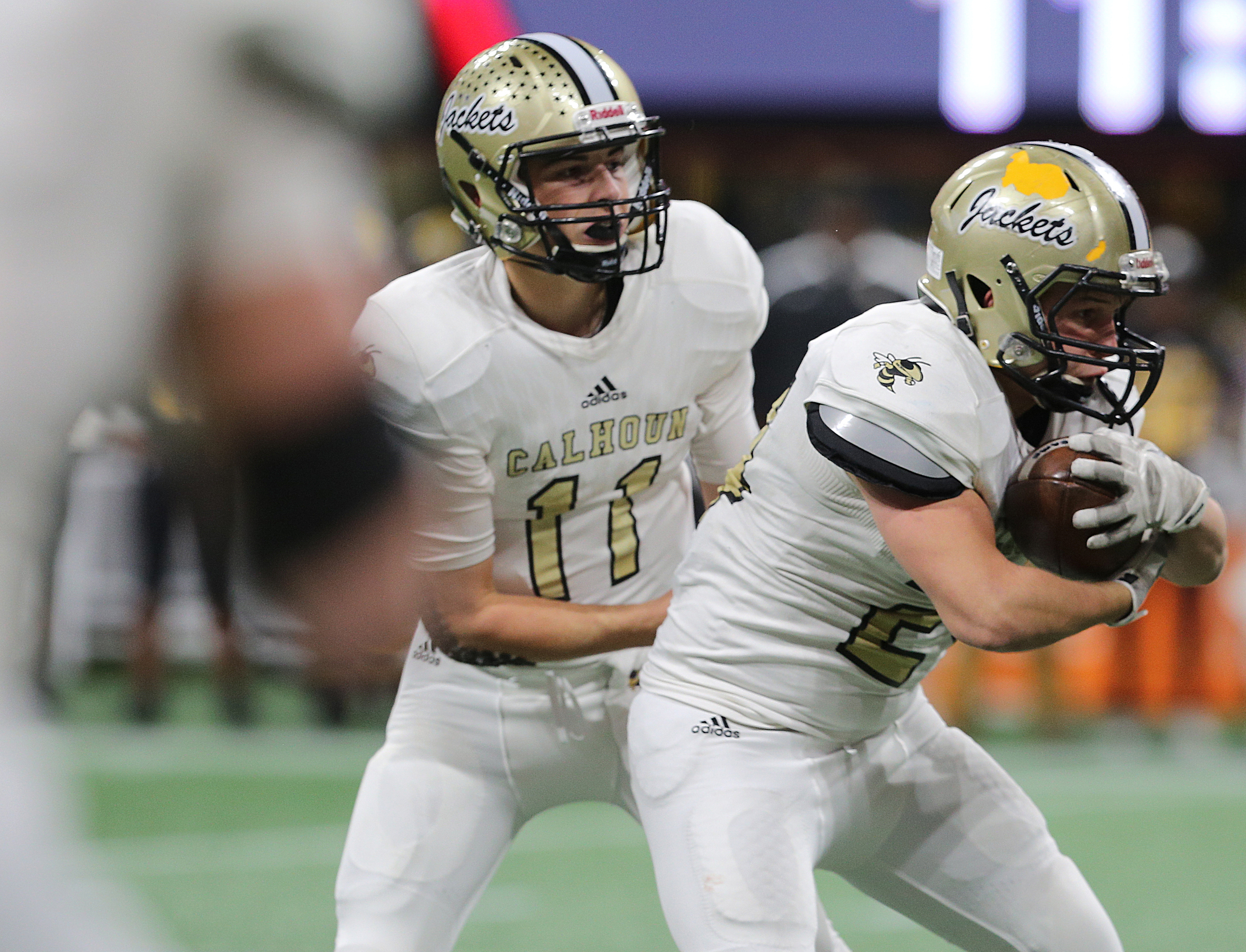 Calhoun quarterback Gavin Gray (11) hands the ball off to running back Zack Fuller (24) during the Class AAA State Championship football game between Calhoun and Peach County Friday, Dec. 8, 2017 at the Mercedes-Benz Stadium in Atlanta, Ga.