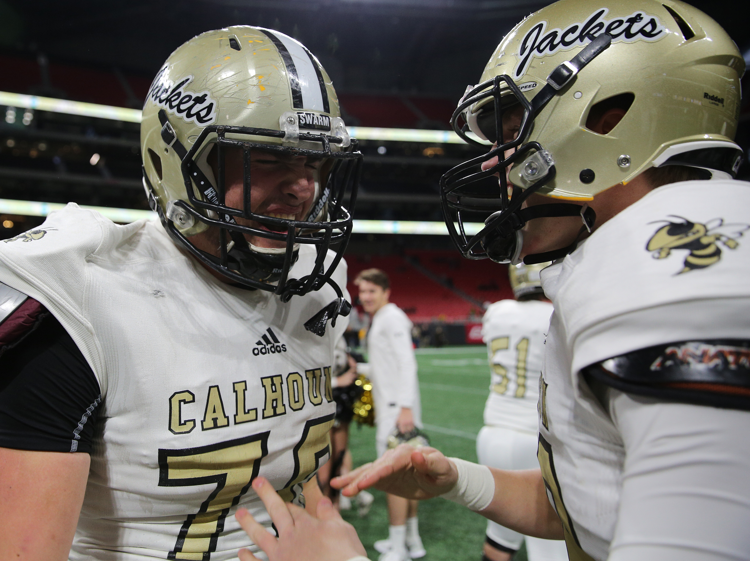 Calhoun's Matthew Ralston (70) and Brett Bradley (49) celebrate following their Class AAA State Championship win over Peach County Friday, Dec. 8, 2017 at Mercedes-Benz Stadium in Atlanta, Ga.