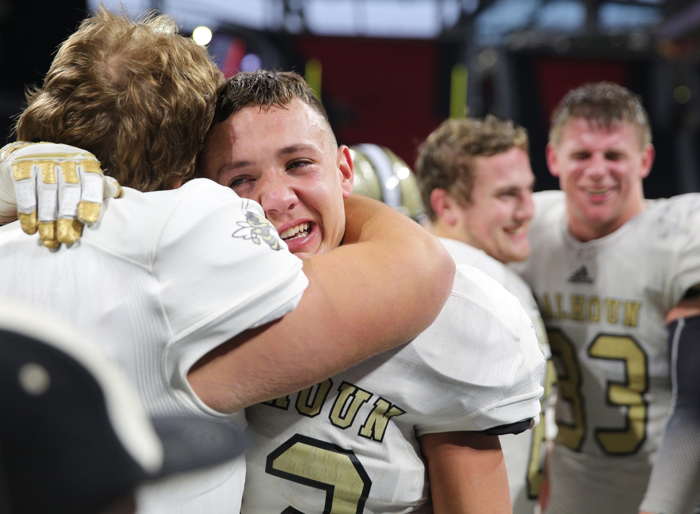 Calhoun's Hudson Dyer (62), on the left, hugs teammate Nate Bonner (11) following their Class AAA State Championship win against Peach County Friday, Dec. 8, 2017 at the Mercedes-Benz Stadium in Atlanta, Ga.