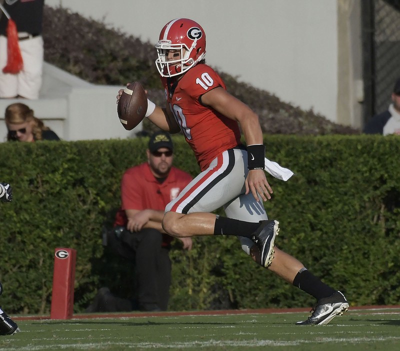 Georgia sophomore quarterback Jacob Eason heads out of bounds moments before sustaining the late hit that resulted in a sprained left knee that caused him to miss multiple games and ultimately lose his starting job to freshman Jake Fromm.