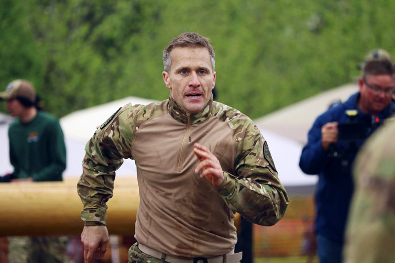 In this April 22, 2017, photo, Missouri Gov. Eric Greitens sprints to the finish line of the obstacle course with teammates from the St. Louis County Police Department during the SEMO SWAT Challenge in Fredericktown, Mo. Greitens is earning a reputation for public displays of physical prowess and revels in the attention, posting videos of his action adventures on Facebook and even using them to help stay fit while keeping a demanding schedule. (Jacob Scott/Daily Journal via AP)