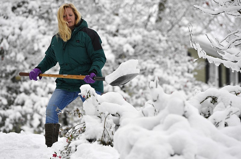 FILE - In this Saturday, Dec. 9, 2017 file photo, Laura Washington shovels her walk after a heavy snow, in Kennesaw, Ga. Thousands remained without electricity across the Deep South on Monday, Dec. 11, days after the storm snapped power lines across the region. Metro Atlanta got several inches of snow Friday and Saturday, while some areas farther north saw up to a foot of snowfall. (AP Photo/Mike Stewart, File)