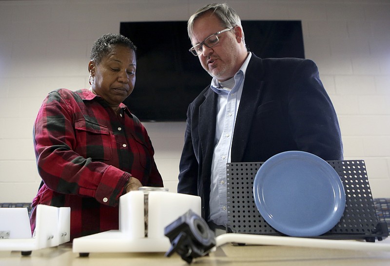 Kim Derrick, left, and Jason Owens check out products developed by Owens's students after they were presented in the Student Life Center at Boyd-Buchanan School on Tuesday, Dec. 12, 2017 in Chattanooga, Tenn. Derrick, the after care director for the school, suffered a stroke that limited the movement in her left arm. Students in the engineering class worked to develop products to help her with everyday tasks.