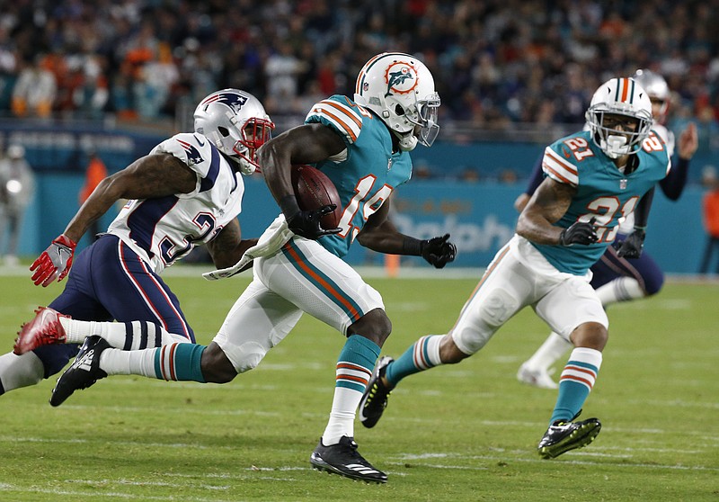 Miami Dolphins wide receiver Jakeem Grant (19) runs ahead of New England Patriots cornerback Jonathan Jones (31), during the second half of an NFL football game, Monday, Dec. 11, 2017, in Miami Gardens, Fla. To the right is Miami Dolphins strong safety Jordan Lucas (21). (AP Photo/Wilfredo Lee)