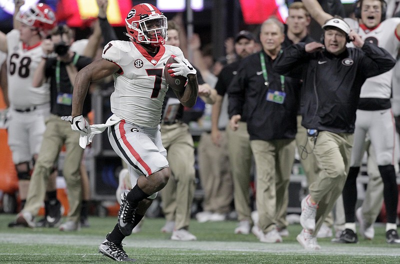 Georgia head coach Kirby Smart, right, runs down the sideline as running back D'Andre Swift (7) runs for a 64-yard touchdown during the Southeastern Conference championship against Auburn at Mercedes-Benz Stadium on Saturday, Dec. 2, 2017 in Atlanta, Ga.