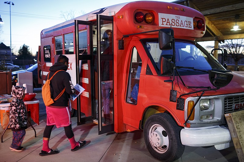 Visitors enter the Passage bus at a stop for UnifiEd's Action Plan for Educational Excellence at the Highland Park Commons on Wednesday, Dec. 13, 2017, in Chattanooga, Tenn. The project committee for APEX plans to travel Hamilton County in a transformed school bus to seek public opinion about ways to solve inequities in the public school system.