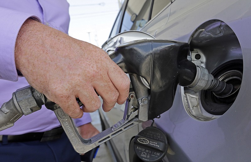 In this Tuesday, May 2, 2017, photo, a motorist fills his tank up at a Chevron gas station in Miami. Prices at the wholesale level rose 0.4 percent in November and 3.1 percent over the past year. It was the biggest annual jump in nearly six years and reflected a big spike in the price of gasoline and other energy products. (AP Photo/Alan Diaz)