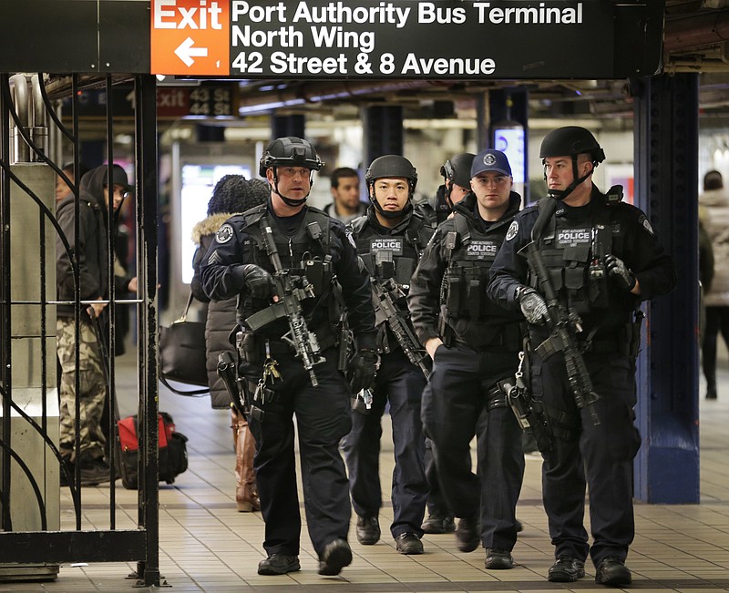 Police officers patrol in the passageway connecting New York City's Port Authority bus terminal and the Times Square subway station on Tuesday, Dec. 12, 2017, near the site of Monday's explosion. Commuters returning to New York City's subway system on Tuesday were met with heightened security a day after a would-be suicide bomber's rush-hour blast failed to cause the bloodshed he intended. (AP Photo/Seth Wenig)