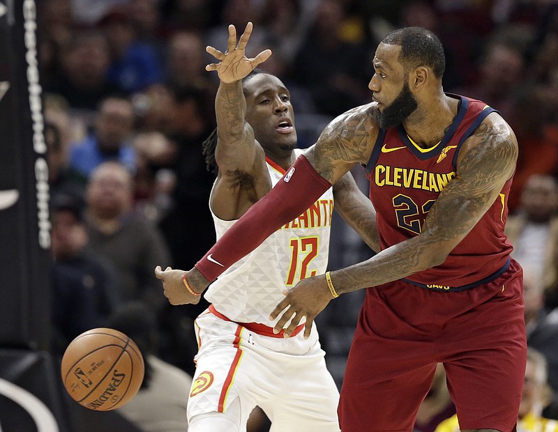 Cleveland Cavaliers' LeBron James, right, passes against Atlanta Hawks' Taurean Prince in the first half of an NBA basketball game, Tuesday, Dec. 12, 2017, in Cleveland. (AP Photo/Tony Dejak)