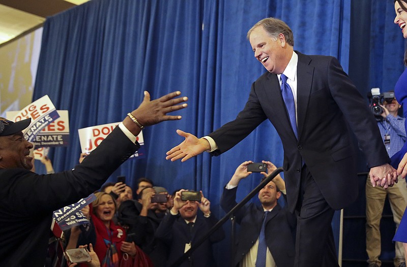 Doug Jones is greeted by a supporter before speaking during an election-night watch party Tuesday, Dec. 12, 2017, in Birmingham, Ala. Jones has defeated Republican Roy Moore, a one-time GOP pariah who was embraced by the Republican Party and the president even after facing allegations of sexual impropriety. (AP Photo/John Bazemore)