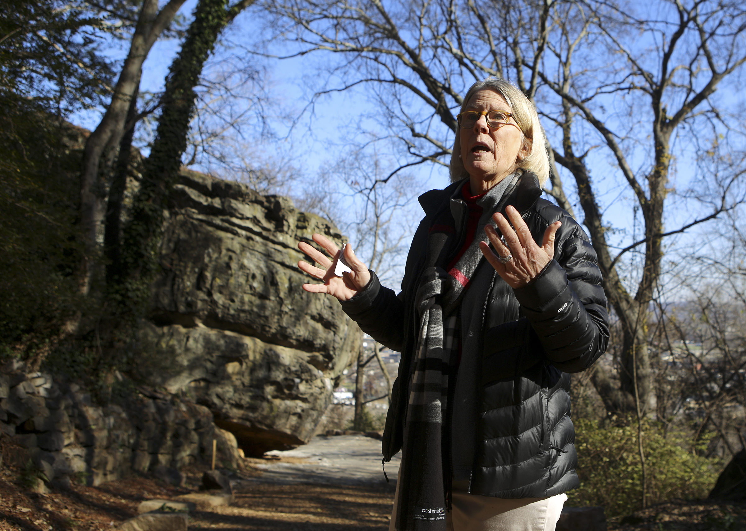 Lookout Mountain Conservancy Executive Director Robyn Carlton talks while giving a tour of the bouldering field off of Old Wauhatchie Pike on Thursday, Dec. 14, 2017 in Chattanooga, Tenn. Behind Carlton on the left is the boulder Cliff Hanger. The Lookout Mountain Conservancy plans to create a conservation-themed neighborhood of 24 homes on 3.5 acres at the site of the old Scholze home place.