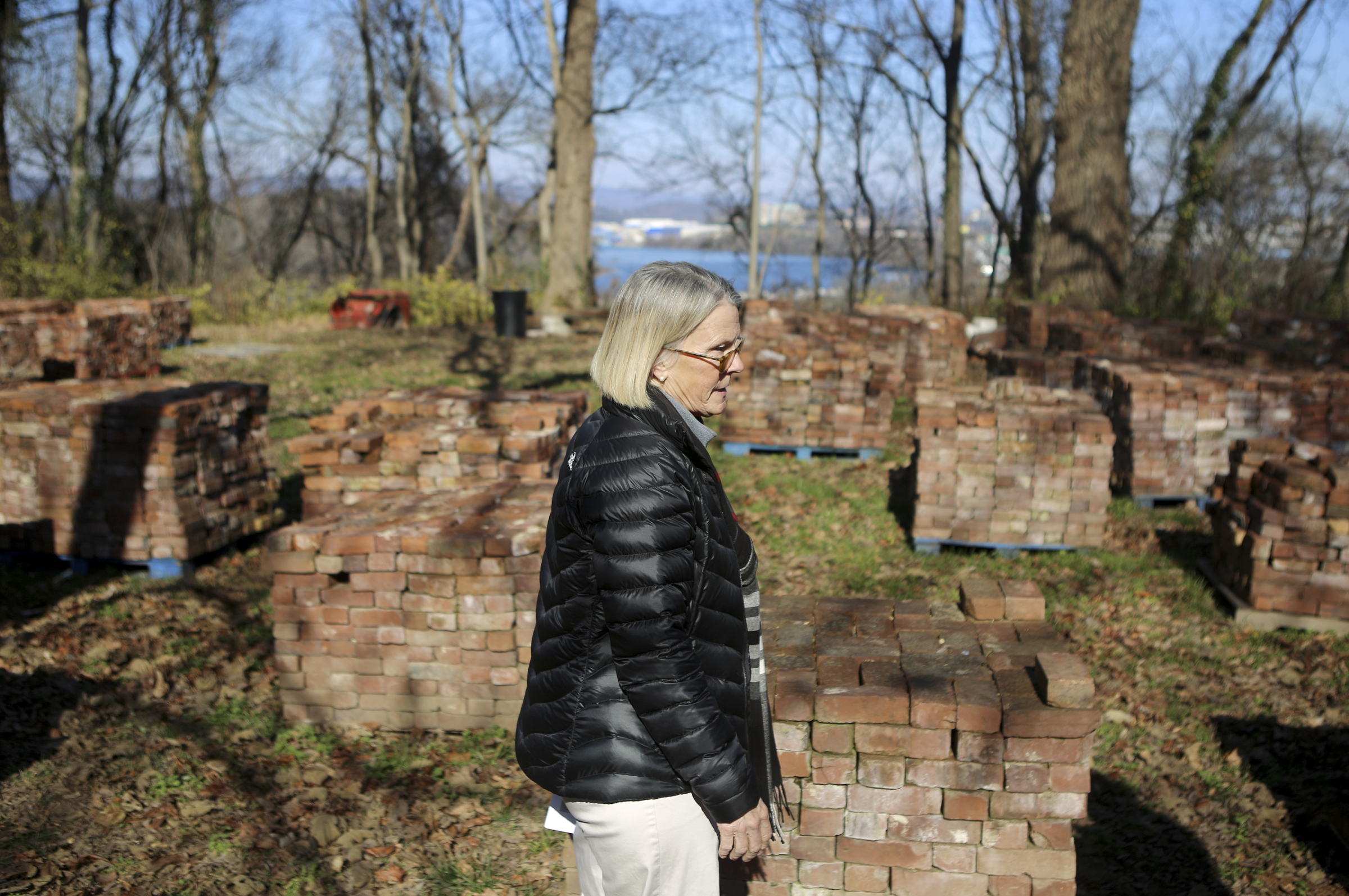 Lookout Mountain Conservancy Executive Director Robyn Carlton gives a tour of the location of the old Scholze mansion off of Old Wauhatchie Pike on Thursday, Dec. 14, 2017 in Chattanooga, Tenn. Stacked behind Carlton are some of the 36,000 bricks recovered from the property. The Lookout Mountain Conservancy plans to create a conservation-themed neighborhood of 24 homes on 3.5 acres at the site of the old Scholze home place.