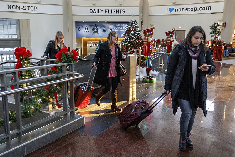Ines Palacios, right, Bethany Smisson, center, and Emily Mauermann exit an escalator while traveling through the Chattanooga Metropolitan Airport on Friday, Dec. 15, 2017, in Chattanooga, Tenn. AAA forecasts a 3.1% increase in holiday travel over last year with an estimated 103 million Americans traveling between Dec. 23rd and Jan. 1st.