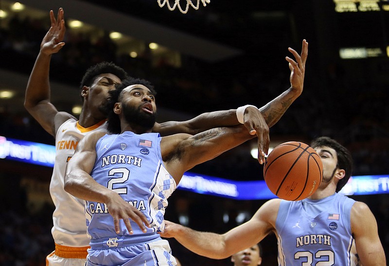North Carolina guard Joel Berry II (2) is defended under the basket by Tennessee forward Kyle Alexander, left,in the first half of an NCAA college basketball game Sunday, Dec. 17, 2017, in Knoxville, Tenn.