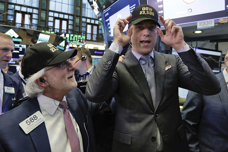 New York Stock Exchange President Tom Farley, right, and trader Peter Tuchman, left, don caps marking "Dow 23,500" after the stock market index crossed the milestone earlier this year.