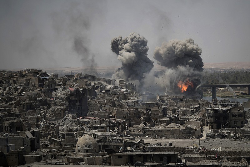 FILE - In this July 11, 2017 file photo, airstrikes target Islamic State positions on the edge of the Old City in Mosul, Iraq. Iraq said Saturday, Dec. 9, 2017 that its war on the Islamic State is over after more than three years of combat operations drove the extremists from all of the territory they once held. Prime Minister Haider al-Abadi announced Iraqi forces were in full control of the country's border with Syria. (AP Photo/Felipe Dana, File)