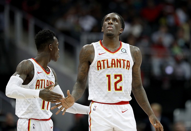 Atlanta Hawks' Taurean Prince, right, high-fives teammate Dennis Schroder, of Germany, in the third quarter of an NBA basketball game against the Miami Heat in Atlanta, Monday, Dec. 18, 2017. (AP Photo/David Goldman)