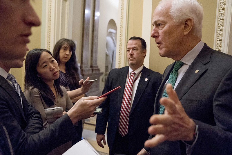 Senate Majority Whip Sen. John Cornyn, R-Texas, speaks to reporters outside his office as Congress prepares to vote on the biggest reshaping of the U.S. tax code in three decades, on Capitol Hill, Tuesday, Dec. 19, 2017, in Washington. (AP Photo/Andrew Harnik)