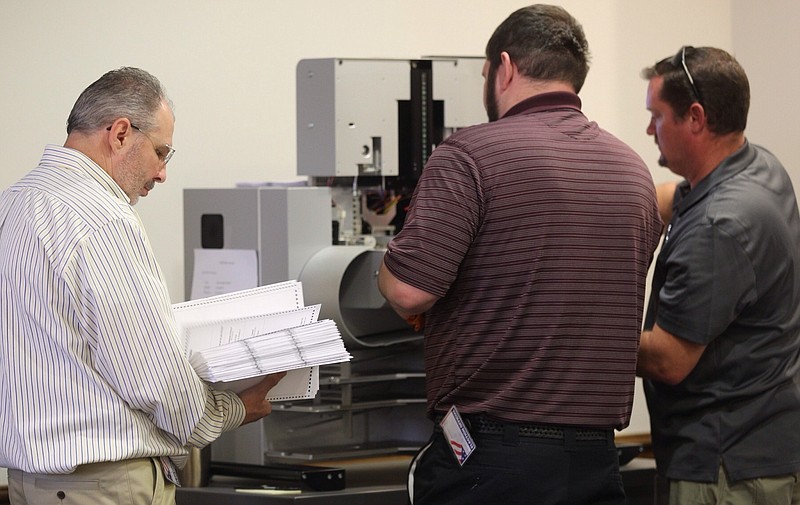 Workers start to remove boxes from a storage room to recount the ballots during the Newport News 94th district recount Tuesday, Dec. 19, 2017 at City Center in Newport News, Va. Officials will use a high-speed machine on to recount results from the 94th District House of Delegates race, which incumbent Republican Del. David Yancey won by 10 votes. Democratic challenger Shelly Simonds requested the recount. (Joe Fudge/The Daily Press via AP)