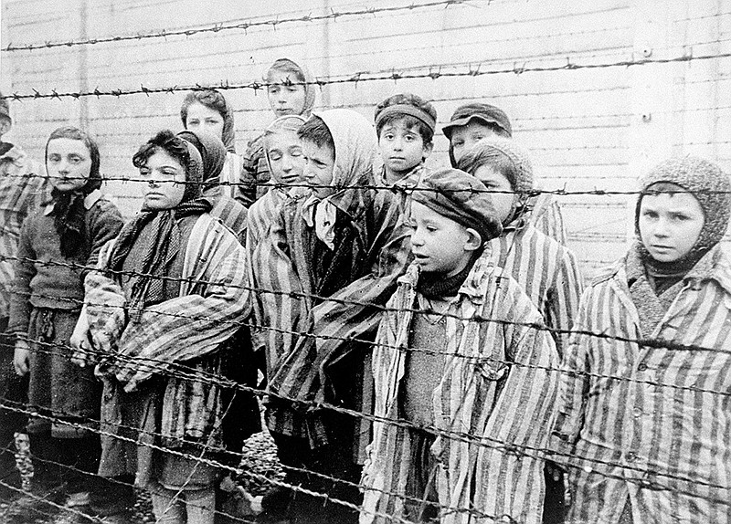 According to the U.S. Holocaust Memorial Museum, the majority of children arriving at camps like Auschwitz were sent directly to the gas chambers upon arrival. Some, however, were chosen for dangerous science experiments or forced manual labor. Pictured here, child survivors of Auschwitz don adult-size prisoner jackets.