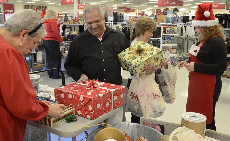 In this 2011 staff file photo, Tom and Cherie Morreale of Sweetwater, Tenn., get Christmas presents wrapped by Joyce Vanderpool, left, and Janet Contley, right, at the TJ Maxx Store on Paul Huff Parkway in Cleveland.