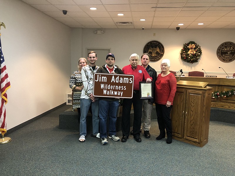 Soddy-Daisy Vice Mayor Jim Adams, fourth from left, is honored for his support of outdoor recreation throughout his 23 years serving the city. He is pictured with the sign that will go up in the Big Soddy Creek Gulf wilderness area to rename the path the "Jim Adams Wilderness Walkway." Also pictured are his son and daughter-in-law, Chris and Jennifer, grandsons Chase and Chance, and wife Shirley Adams.