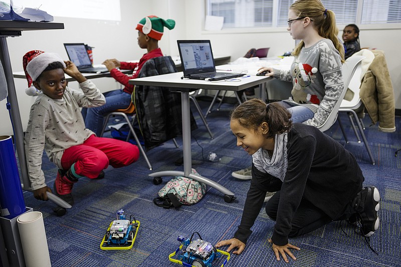 Maggie Campbell, Sabriyah Stallion, Timothy Rice, and Aaron Williams, clockwise from right, program robots in a robotics class at Tech Town's winter break camp in the Edney Innovation Center on Friday, Dec. 22, 2017, in Chattanooga, Tenn. Tech Town offers technology-centric camps and education for children in subjects ranging from video production and computer coding to electronics and robotics.