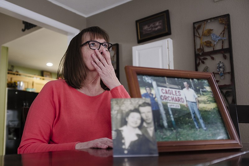Pictures of Kathy Shelby's parents, Carmie and William Cagle, are displayed on a table as Shelby talks Thursday, Dec. 21, 2017, about her family's history of cancer in the dining room of her home in Chattanooga, Tenn. Shelby and many of her family members have been diagnosed with Lynch Syndrome, a genetic condition that increases their risk of cancer.