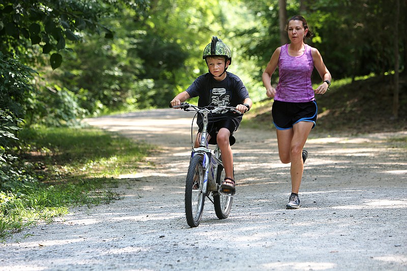 Isaac Wheatcroft, 7, rides his bike with Crystal Faudi running just behind him Wednesday, July 12, 2017, at Greenway Farm in Hixson, Tennessee. The Faudi and Wheatcroft families met up at the park to enjoy the day.