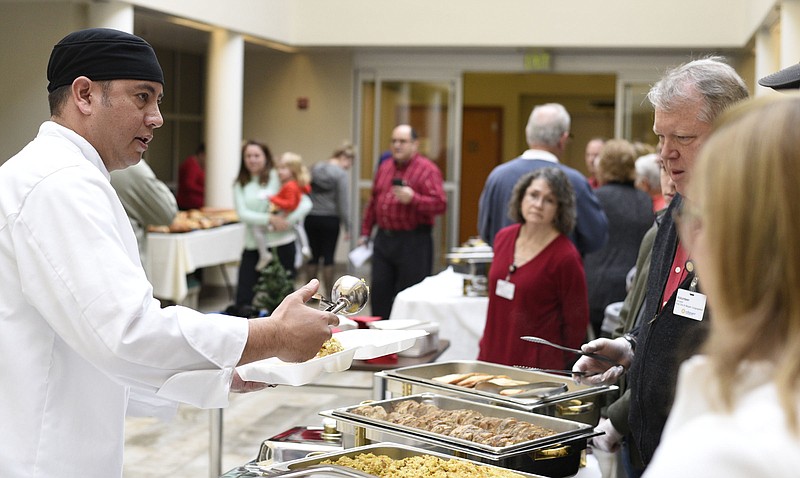 Erlanger Hospital Executive Chef Maxwell DeRussy, far left, gives instructions about the proper serving size to the volunteers.  Members of the B'Nai Zion and Mizpah Congregations partnered with Erlanger Health System to serve a free Christmas lunch for family members of patients and associates at the Erlanger Baroness Hospital on December 25, 2017.  