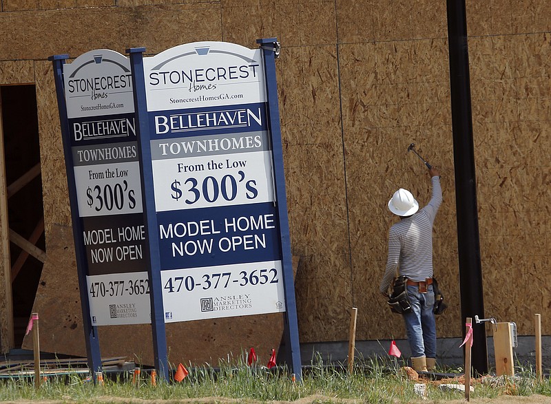 FILE - In this Tuesday, May 16, 2017, file photo, a construction worker continues work on new town homes under construction in Woodstock, Ga. The Standard & Poor's CoreLogic Case-Shiller home price index, which tracks the value of homes in 20 major U.S. metropolitan areas, is due out Tuesday, Dec. 26, 2017.  (AP Photo/John Bazemore, File)