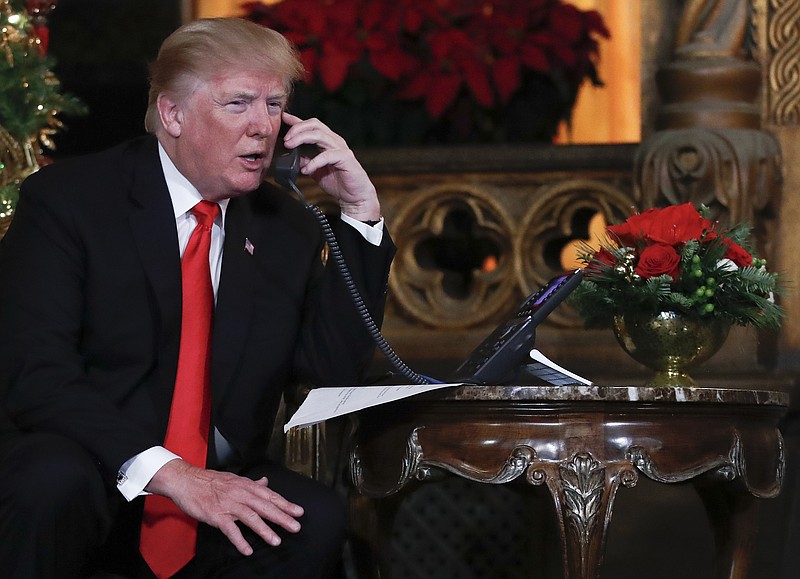 President Donald Trump speaks on the phone with children as they track Santa Claus' movements with the North American Aerospace Defense Command (NORAD) Santa Tracker on Christmas Eve at the president's Mar-a-Lago estate in Palm Beach, Fla., Sunday, Dec. 24, 2017. (AP Photo/Carolyn Kaster)