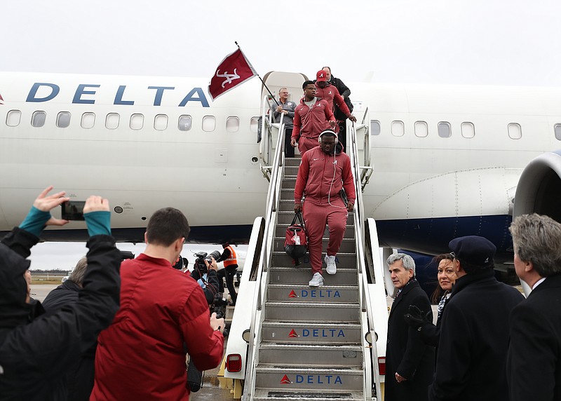 Alabama football players exit the plane Wednesday after arriving in New Orleans for Monday night's Sugar Bowl against Clemson.