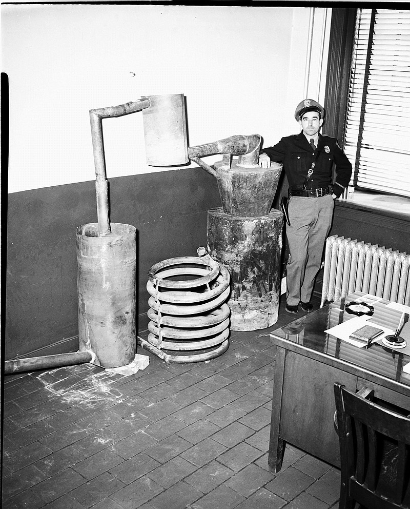 A law enforcement officer guards a raided still.Staff File PhotoDade County deputy sheriffs in the early 1980s examine a massive still found in the Big Woods community of Sand Mountain.