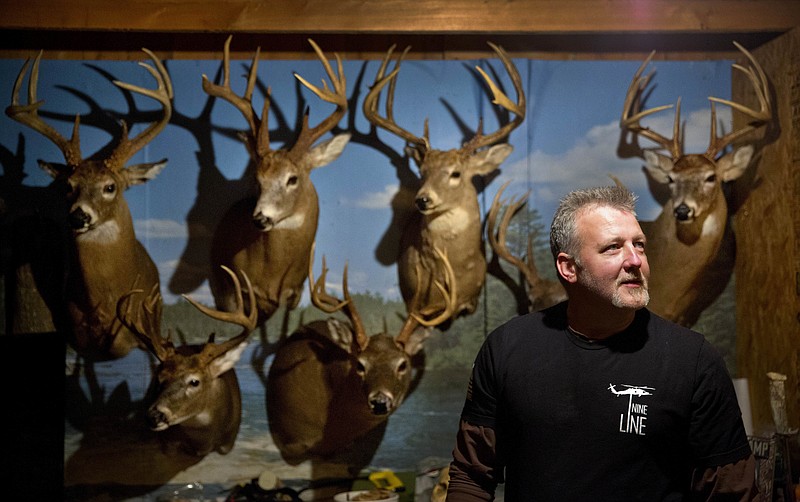 Dale Ferguson stands in his hunting cabin decorated with deer he's killed, mounted on the wall, as he prepares to go out on a hunt in Isonville, Ky., Wednesday, Dec. 13, 2017. Ferguson has three priorities in life and in politics, in this order: God, guns, family. Like it used to be, he says. And now he sees himself reflected in America's president. (AP Photo/David Goldman)