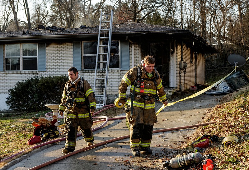 Firefighters place a fire line around a home after a morning duplex fire at 4605 Plaza Hills Lane in Hixson that left one dead Friday, Dec. 29, 2017, in Chattanooga, Tenn.