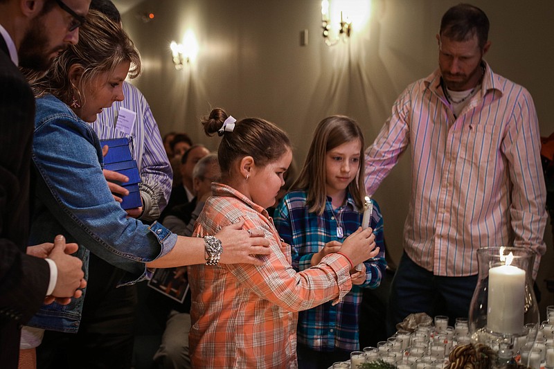 One by one, families approach the altar to light candles in honor of their loved ones during Heritage Funeral Home's Candlelight Memorial Service. (Contributed photo by Casey Yoshida)