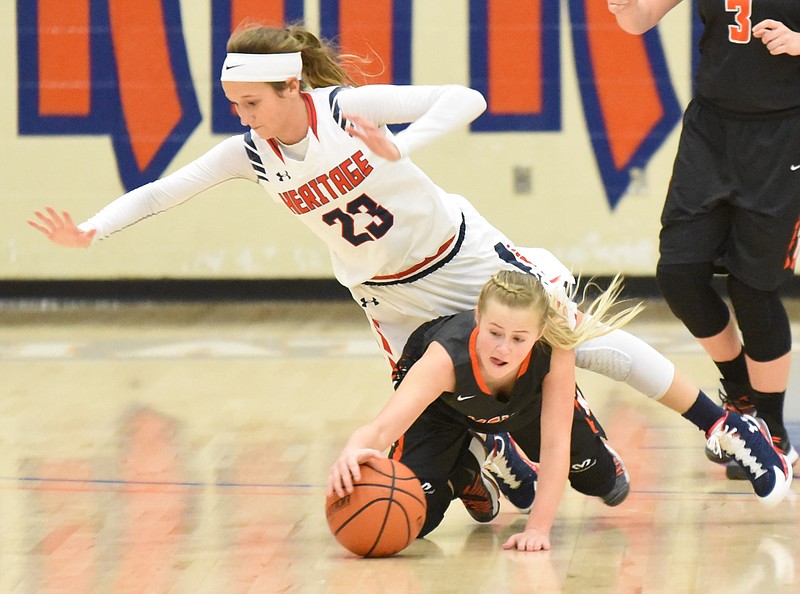 Meigs County's Jacelyn Stone reaches to control a loose ball as Heritage's Ansley Bice (23) leaves her feet in the girls 4 p.m.  semi-final game Friday afternoon in the Best of Preps tournament at Chattanooga State.