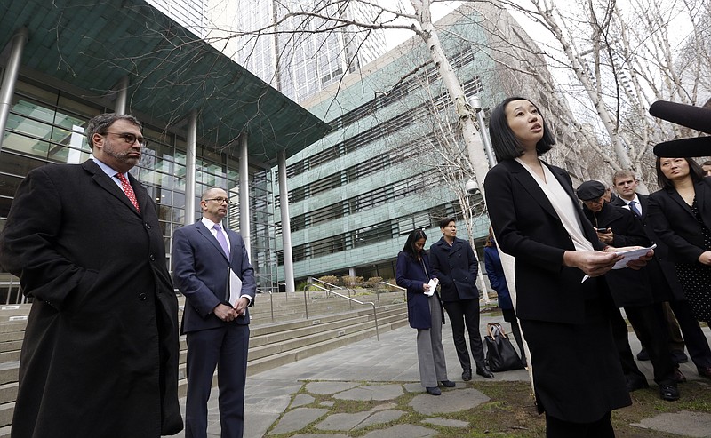 In this Dec. 21, 2017, file photo, Mariko Hirose, right, a litigation director at the Urban Justice Center, addresses reporters as Mark Hetfield, president & CEO of HIAS, left, and Rabbi Will Berkowitz, Jewish Family Service of Seattle CEO, look on in front of a federal courthouse after speaking with media in Seattle. The government has asked a federal judge to change his order that partially lifted a Trump administration refugee ban. (AP Photo/Elaine Thompson, File)
