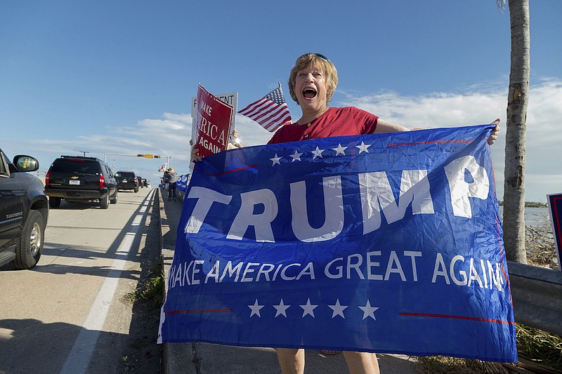 Mary Jude Smith cheers for President Donald Trump as his motorcade passes by on Southern Blvd. enroute to his Mar-a-Lago estate from Trump International Golf Club, Thursday, Dec. 28, 2017, in West Palm Beach, Fla. (Greg Lovett/Palm Beach Post via AP)