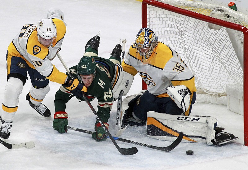 Minnesota Wild's Tyler Ennis (63) tripped up at the goal by Nashville Predators Colton Sissons (10) and Pekka Rinne (35), of Finland, during the first period of an NHL hockey game on Friday, Dec. 29, 2017, in St. Paul, Minn. (AP Photo/Andy Clayton-King)