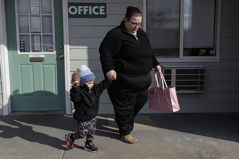 Rachel Galorath and her son Jackson Prouse leave the office of the Hamilton Inn, where Galorath lives and works, on Friday, Dec. 29, 2017, in Chattanooga, Tenn. Galorath and Jackson have been enrolled in the city's Baby University program for almost two years.
