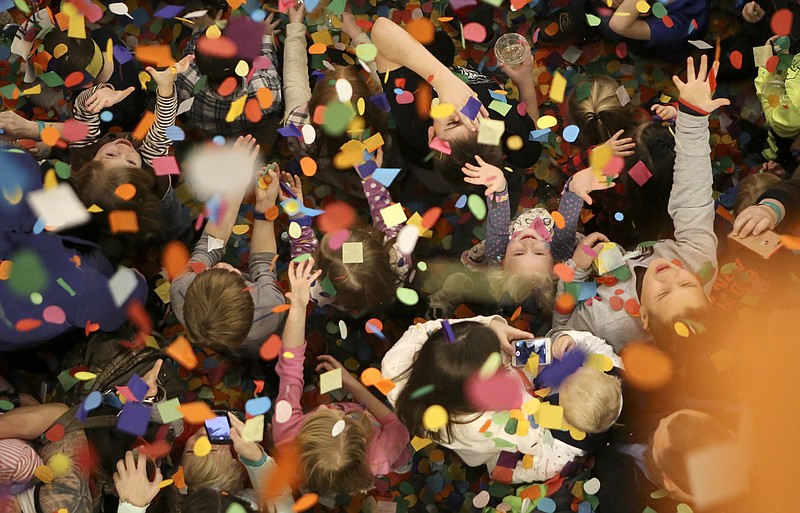 Kids react as confetti falls during a New Year's celebration at the Creative Discovery Museum on Sunday, Dec. 31, 2017 in Chattanooga, Tenn. The annual event is held specifically for children to celebrate the New Year with events like a confetti drop, an appearance by Father Time and fireworks simulated by stomping on bubble wrap.