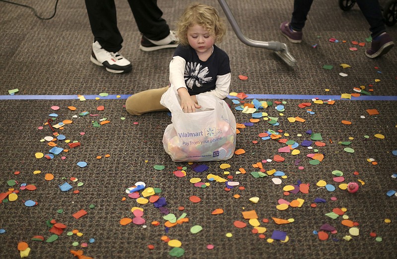 Four-year-old Scarlett Kirstein picks up confetti during a New Year's celebration at the Creative Discovery Museum on Sunday, Dec. 31, 2017 in Chattanooga, Tenn. The annual event is held specifically for children to celebrate the New Year with events like a confetti drop, an appearance by Father Time and fireworks simulated by stomping on bubble wrap.