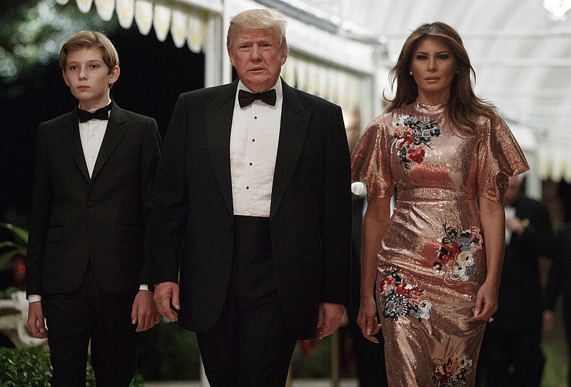 President Donald Trump arrives for a New Year's Eve gala at his Mar-a-Lago resort with first lady Melania Trump and their son Barron, Sunday, Dec. 31, 2017, in Palm Beach, Fla. (AP Photo/Evan Vucci)