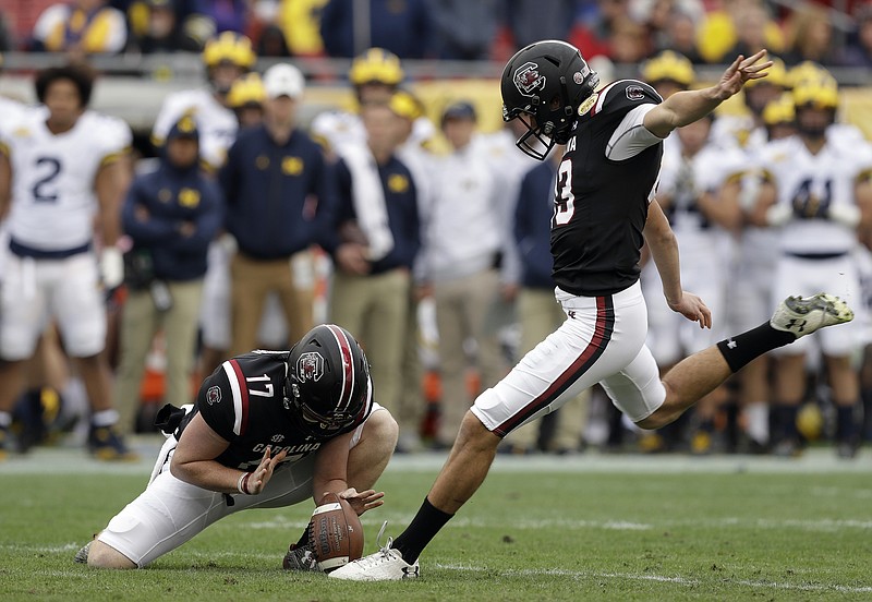 South Carolina place kicker Parker White prepares to kick a field goal against Michigan during the first half of the Outback Bowl NCAA college football game Monday, Jan. 1, 2018, in Tampa, Fla. Holding is Danny Gordon. (AP Photo/Chris O'Meara)